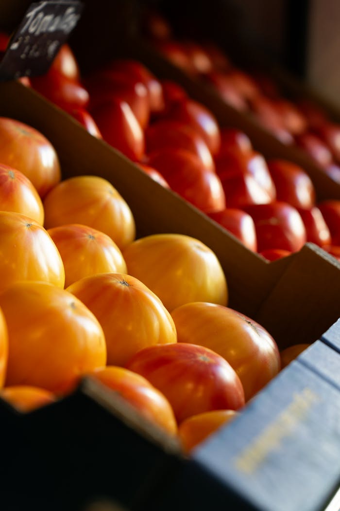 Close-up of colorful tomatoes showcased in a market stall, highlighting fresh produce.